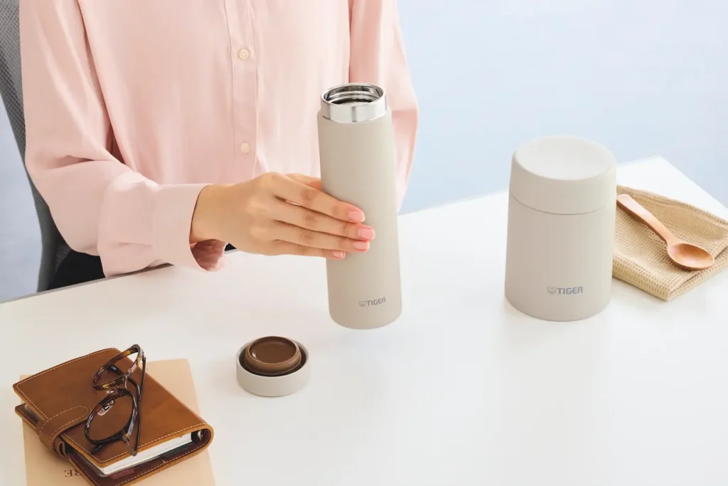 Holding her bottle at the table.