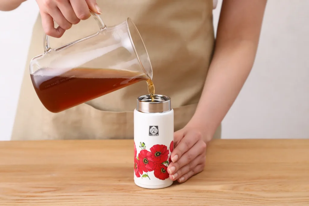Pouring hot tea into the bottle.